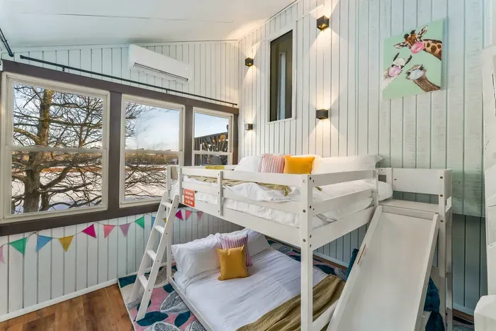 A playful, light-filled bunk room with full-over-full beds, lake views, and blackout curtains (added after photos were taken) for deep sleep. Perfect for kids or lightweight teens—top bunk max 150 lbs for safety and sweet dreams.