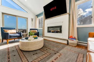 Sun-drenched and cozy, this stylish living space invites connection—whether it’s movie night by the fireplace, board games with the kids, or sipping coffee with lake views and luxe textures all around.