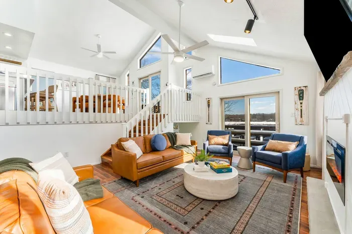 Enjoy abundant natural light and panoramic views in this open concept living space.  With vaulted ceilings, large windows, and easy access to the deck, it's perfect for relaxing or entertaining in a bright, inviting atmosphere!