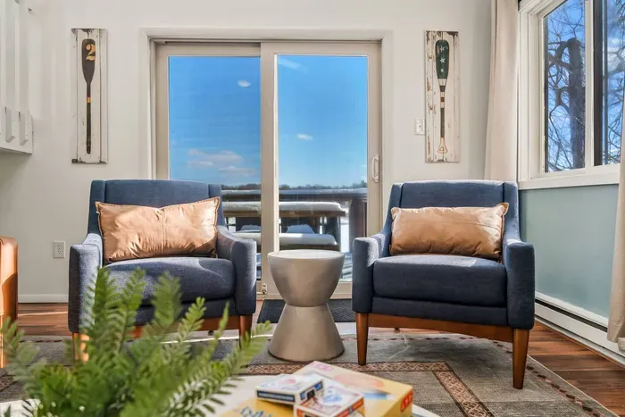 Relax in this cozy space with inviting chairs and breathtaking views through sliding doors that lead to the deck.