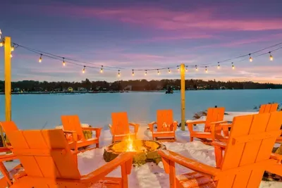 Gather around the fire pit with panoramic lake views as the sunset paints the sky.  Twinkling string lights and cozy seating create a magical space for stargazing, storytelling, and creating lasting memories.