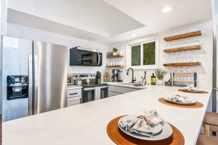 This bright, modern kitchen has it all—stainless steel appliances, open shelving, a full coffee bar, blender, and dishwasher. Perfect for everything from pancake breakfasts to wine & charcuterie nights.