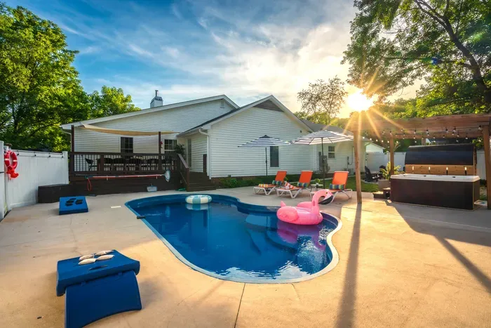 Private backyard oasis with pool, hot tub, pergola, and sunny lounge area