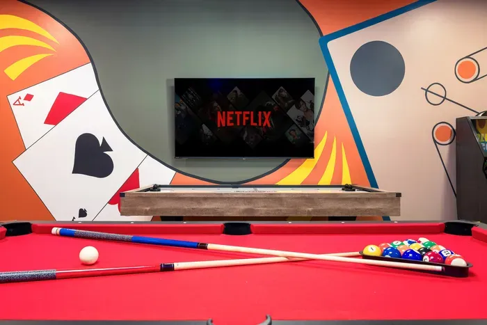 Vibrant game room with pool table, mural wall, and smart TV streaming