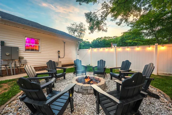 Cozy backyard fire pit with Adirondack seating and twinkle lights