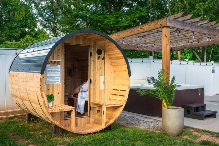 Private barrel sauna and hot tub oasis in a peaceful fenced backyard