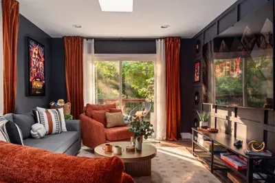 Cozy entertainment lounge with big-screen TV and leafy balcony views