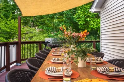 Spacious shaded deck with alfresco dining, grill, and lush green views