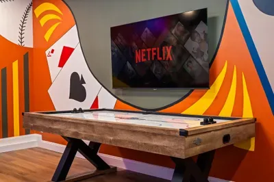 Colorful game room with air hockey table and large streaming TV