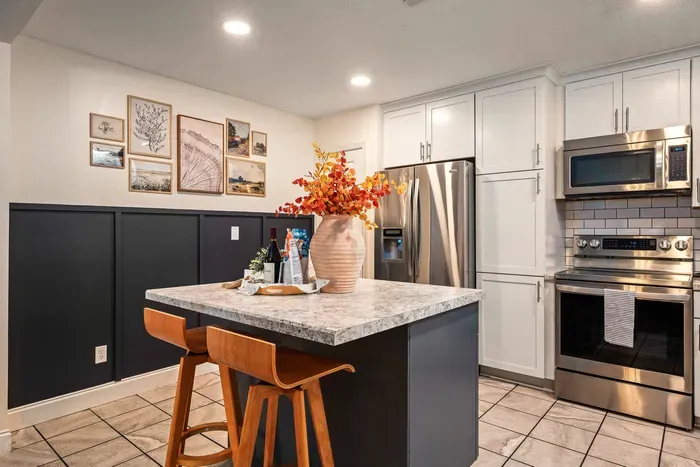 Bright modern kitchen with island seating and stainless steel appliances