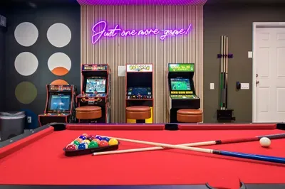 Retro arcade room with neon lights and a full-size pool table