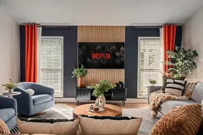 Modern, cozy lounge with Netflix TV, bold accents, and lots of natural light