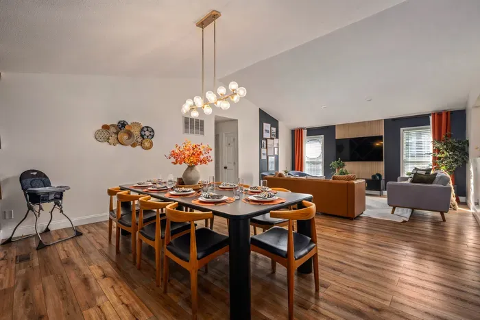 Open dining and living space with vaulted ceilings and stylish décor