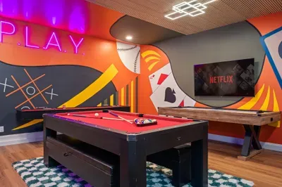 Stylish game room with pool, shuffleboard, Netflix, and neon vibes
