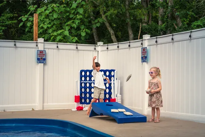 Family-friendly poolside games in a private fenced backyard retreat