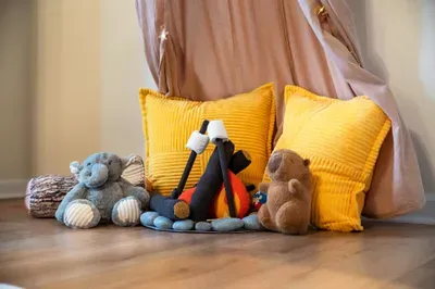 Cozy kids’ play corner with plush toys, floor cushions, and a whimsical canopy