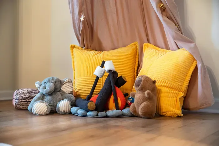 Cozy kids’ play corner with plush toys, floor cushions, and a whimsical canopy