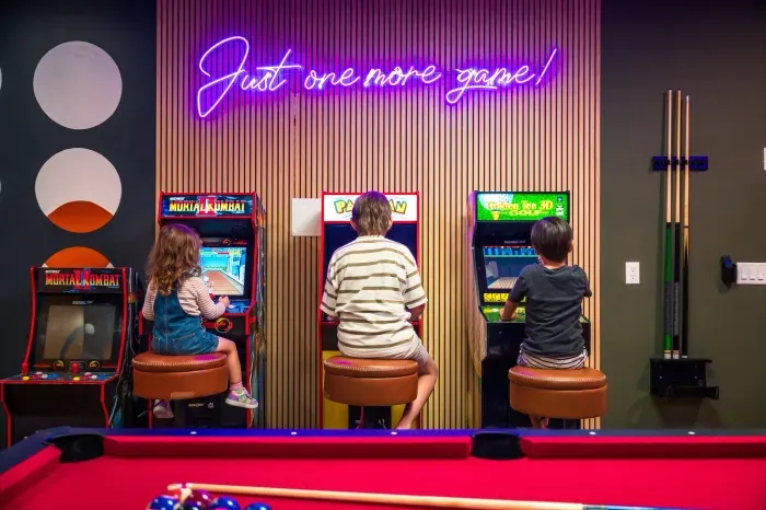 Fun-filled game room with arcade classics, pool table, and neon vibes