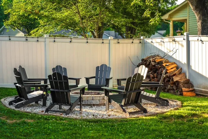 Cozy private fire pit patio with Adirondack chairs and string lights