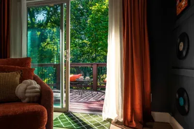 Cozy lounge with private deck and peaceful tree-filled views