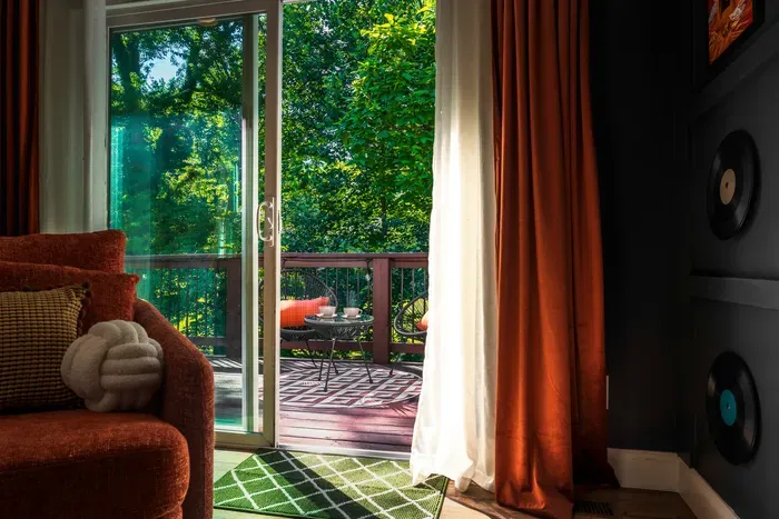 Cozy lounge with private deck and peaceful tree-filled views