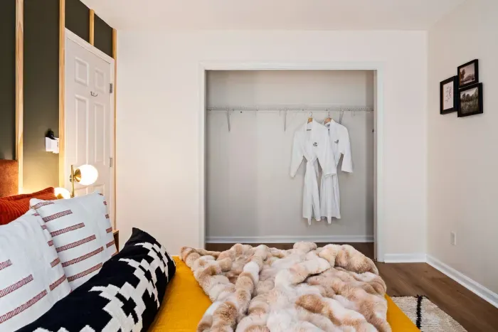 Cozy minimalist bedroom with plush bedding and spacious open closet