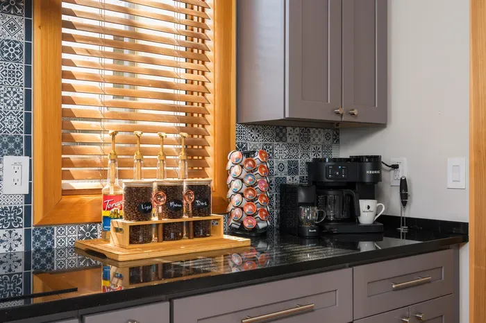 The coffee bar handles every early riser before the rest of the house stirs. Pods, syrups, French press, all set so the slow drinkers and the early hikers both get going.