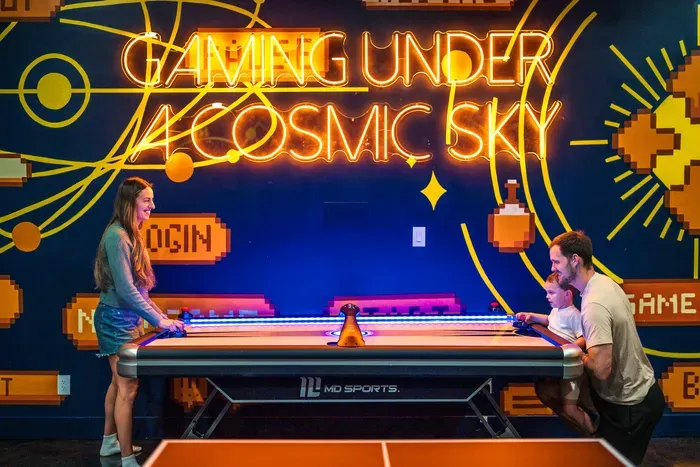 Three generations crowded around the air hockey, the puck flying, everyone yelling. The kind of game-room moment that ends up the actual highlight of the whole week.