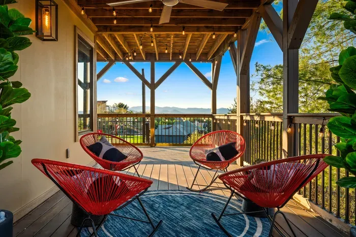Covered balcony with mountain views, string lights, and chic lounge seating