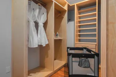 A walk-in closet that actually fits a week of luggage for everyone, with waffle robes waiting on the hook and a travel crib already set up for the littlest guest in the group.