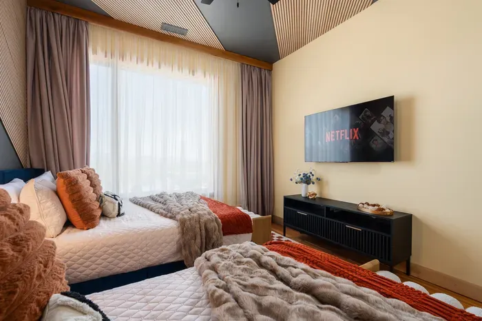 The shared bedroom keeps the sleepover energy upstairs. Movie on, curtains drawn, and the younger crew has a place that feels like their own zone.