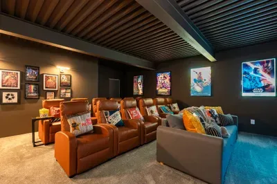 The lower-level theater for the long Saturday night. Sink into the recliners, big screen on, karaoke mics waiting for whoever calls round two after the credits roll.