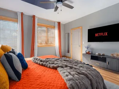 This bedroom gives one guest a real reset spot: TV when the house gets loud, mountain air nearby, and enough quiet to come back downstairs refreshed.
