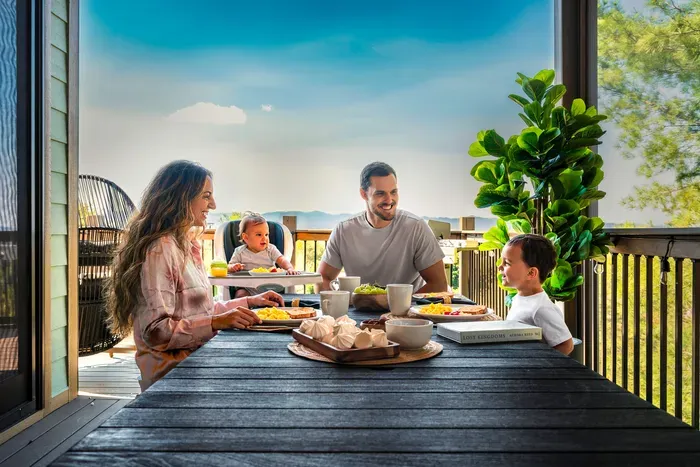 Long table set on the covered deck, the ridge stretching open past the rail, plates and mugs ready. The outdoor dinner you'll still be talking about on the drive home.