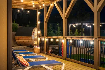 Cozy covered deck with lounge chairs, string lights & a private sauna