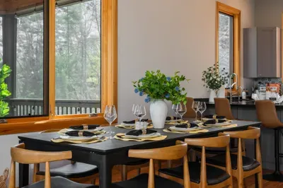 Slow Sunday dinner at the long table with the trees through the window and a second pour going around. Asheville turns one course into three without anyone trying.