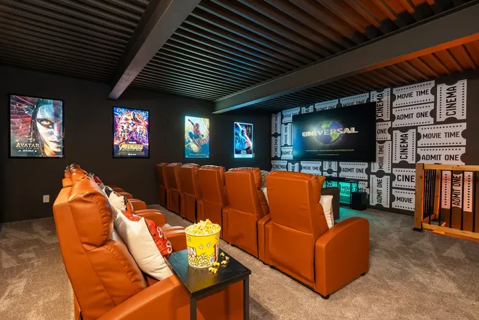 The whole group in the theater, recliners across the back, sofa up front for whoever calls the best seat. The lower-level anchor for the rainy afternoon and the long Saturday night.