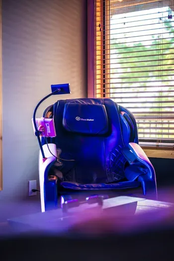 The massage chair tucked into the upstairs wellness corner, the kind of amenity you forget you booked until your legs hit it after a long Blue Ridge day on the trails.