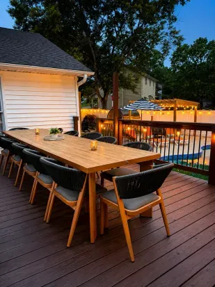 Spacious deck dining with string lights overlooking the pool