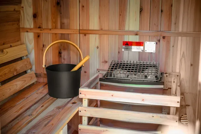 Private cedar sauna with traditional heater for a relaxing spa-like stay
