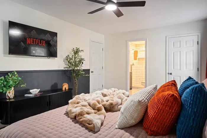 Cozy bedroom with streaming TV, plush bedding, and en suite bath
