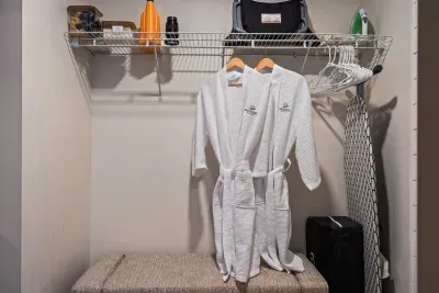 Organized closet with bench, robes, and handy storage space