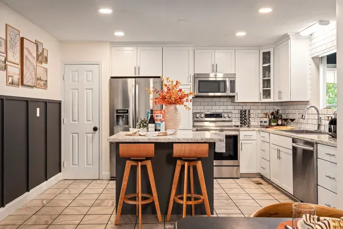 Bright modern kitchen with island seating and stainless steel appliances
