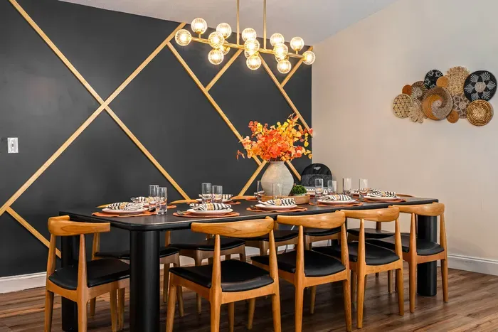 Stylish dining room for 8 with bold accent wall and modern chandelier