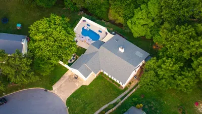 Private backyard pool oasis with spacious yard and serene tree-lined setting
