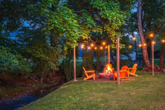 Creekside fire pit with string lights for cozy evenings outdoors