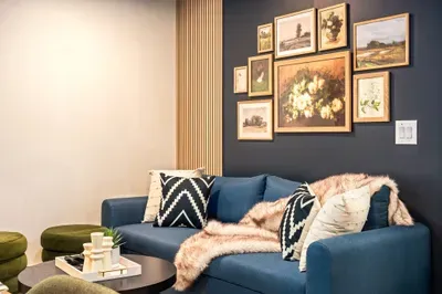 Cozy designer lounge with blue sofa and curated gallery wall