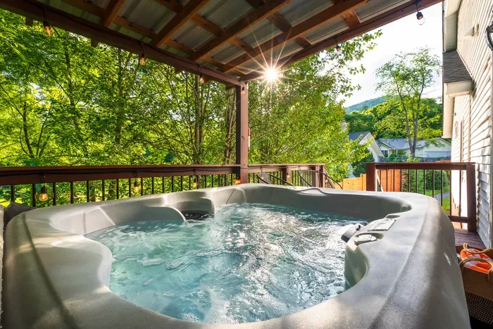 Private covered hot tub with serene wooded views and sunset glow