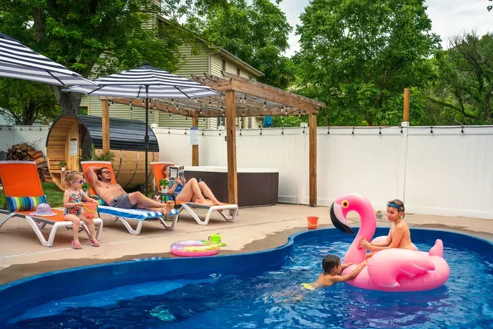 Private family-friendly pool oasis with hot tub, loungers, and shaded seating