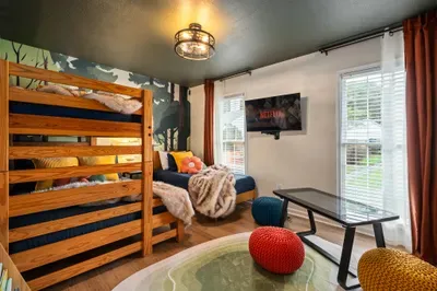 Cozy bunk room with TV, daybed, and bright natural light